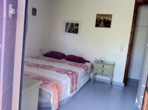 a small bedroom with a bed and a night stand at Agrelia House in Ouranoupoli