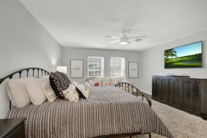 a bedroom with a bed and a ceiling fan at Wow! Haus with Hot Tub, Fire Pit and Games Galore! in Fredericksburg