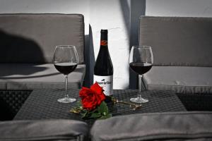a bottle of wine and two glasses on a table at Casa Pepe La Rosa Atico in Tolox