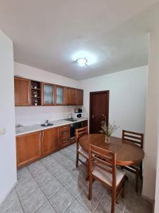a kitchen with a wooden table and chairs and a table and a table at Edelweiss Inn Aparthotel, Apartment 32 in Bansko