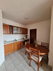 a kitchen with a wooden table and a table and chairs at Edelweiss Inn Aparthotel, Apartment 32 in Bansko