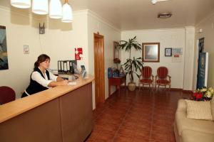 a woman is sitting at a counter in a salon at Alagoa Azul in Altura