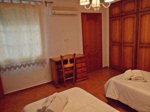 1 dormitorio con escritorio, 1 cama y 1 mesa en Casa Pepe La Rosa Atico en Tolox