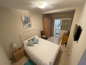 a bedroom with a white bed and a television at Palast Stieg in Jerez de la Frontera