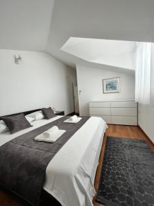 a bedroom with a large bed with towels on it at SKY - beautiful rooftop apartment with shared pool in Split +24 photos