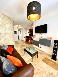 uma sala de estar com um sofá e uma televisão em Drissia&Othman Bella Noche em Carcassonne