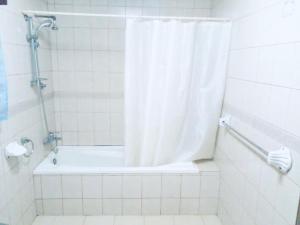 a bathroom with a shower and a tub with a shower curtain at ZUNOX GUEST HOUSE in Freetown +57 photos