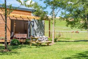 Cabaña de madera con mesa de picnic en el patio en Sunset Cabins at The Oaks Woodland Retreat en Barnstaple
