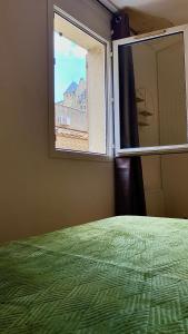 um quarto com uma cama verde e uma janela em Drissia&Othman Bella Noche em Carcassonne