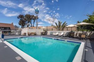 a swimming pool at a resort with tables and chairs at Best Western Country Inn Temecula in Temecula