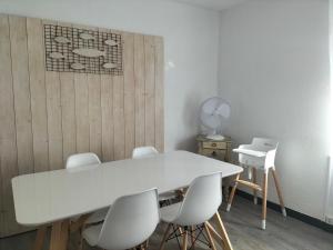 una mesa blanca y sillas en una habitación en La Maison CANTHEZ Wifi en Sigean
