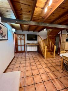 una sala de estar con techos de madera y una escalera. en Increible Casa ideal Familias en Ushuaia