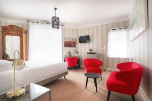 ラ・ボールにあるBest Western Brittany La Baule Centreのベッドルーム1室(赤い椅子、ベッド1台、テーブル付)