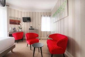 um quarto com cadeiras vermelhas, uma mesa e uma cama em Best Western Brittany La Baule Centre em La Baule