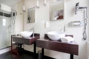 łazienka z 2 umywalkami i prysznicem w obiekcie Best Western Brittany La Baule Centre w mieście La Baule-Escoublac