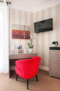 a desk with a red chair and a tv on a wall at Best Western Brittany La Baule Centre in La Baule