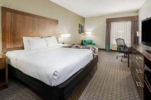 um quarto de hotel com uma cama grande e uma televisão em La Quinta by Wyndham Fort Worth Eastchase em Arlington