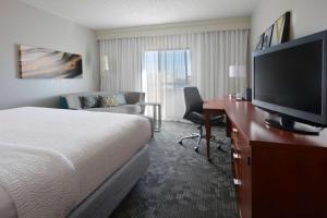 a hotel room with a bed and a flat screen tv at Sonesta Select Dallas Central Expressway in Dallas