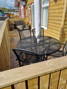 ein Glastisch und Stühle auf einer Terrasse in der Unterkunft Pet friendly sleeps 6 Chalet Bridlington free elec in Bridlington