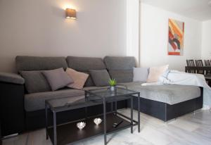 a living room with a couch and a glass table at Agradable adosado con piscina la Hidalga in Benalmádena