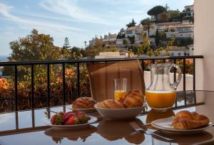 a table with two plates of food and a glass of orange juice at Agradable adosado con piscina la Hidalga in Benalmádena +45 photos