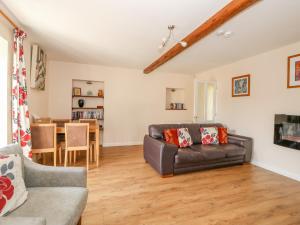 a living room with a couch and a table at The Granary Cottage in Gayton
