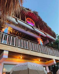 un edificio con tetto di paglia e balcone di Fatwave Surf Resort a San Juan
