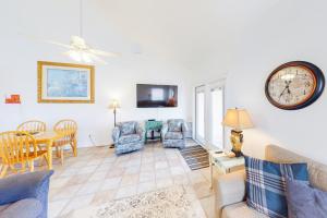 a living room with a clock and a table and chairs at Acapulco Unit A in South Padre Island