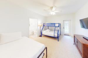 a bedroom with a blue bunk bed and a tv at Acapulco Unit A in South Padre Island