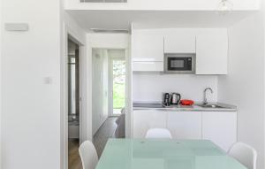 a white kitchen with a white table and chairs at Bilo 4 Confort in Stintino