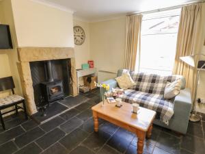 a living room with a couch and a fireplace at Cosy Cottage in Potto