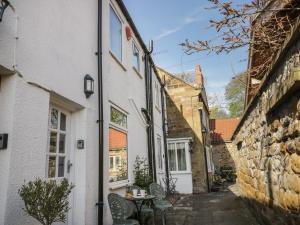a small alleyway between two buildings with a table and chairs at Cosy Cottage in Potto