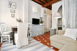Il comprend un salon doté d'un canapé et d'une table avec une télévision. dans l'établissement Gina Guest House, à Florence