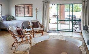 - un salon avec un canapé, une table et des chaises dans l'établissement La Dolce Vita Whangamata, à Whangamata