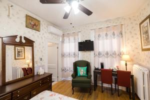 a bedroom with a desk and a chair and a table at Prince Street Suites in Charlottetown