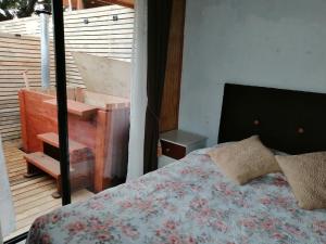 una camera con letto e un balcone con pianoforte di Cabañas Las Puconinas a Pucón
