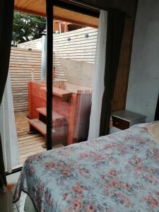 una camera con letto e un balcone con vasca di Cabañas Las Puconinas a Pucón