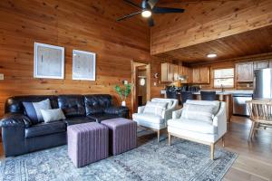 ein Wohnzimmer mit einem Sofa und Stühlen sowie eine Küche in der Unterkunft Constellation Station View Hot Tub Fireplace in Gatlinburg
