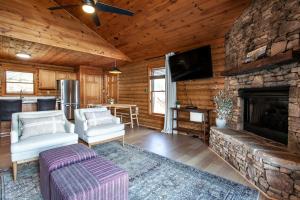 ein Wohnzimmer mit einem Steinkamin in einer Blockhütte in der Unterkunft Constellation Station View Hot Tub Fireplace in Gatlinburg