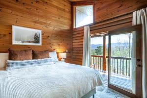 ein Schlafzimmer mit Bett und Balkon in der Unterkunft Constellation Station View Hot Tub Fireplace in Gatlinburg