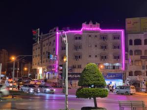 a building with pink lights on the side of it at Sara Crown Hotel in Irbid