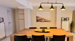 comedor con mesa de madera y sillas en Familie appartement hartje Knokke met optie parking, en Knokke-Heist