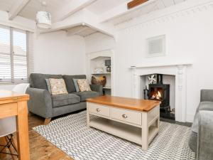 a living room with a couch and a fireplace at Mole Cottage in Mousehole