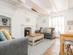 uma sala de estar com dois sofás e uma lareira em Mole Cottage em Mousehole
