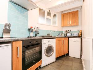 a kitchen with a washer and dryer in it at Mole Cottage in Mousehole +17 photos