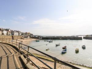 a group of boats in the water next to a beach at Mole Cottage in Mousehole