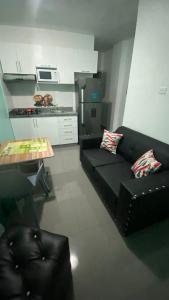 a living room with a black couch and a table at RESIDENCIAL DOÑA GLORIA in San Felipe de Puerto Plata