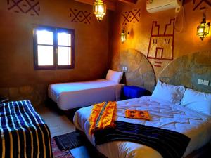 a bedroom with two beds and a window at Auberge restaurant Afoud in Agoudal