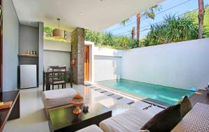 ein Wohnzimmer mit einem Pool in einem Haus in der Unterkunft Samaja Villas Seminyak in Seminyak