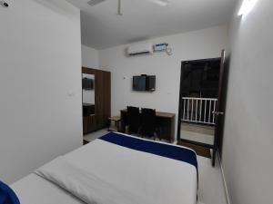 a bedroom with a bed and a desk and chairs at The Jugglers Rest in Mysore